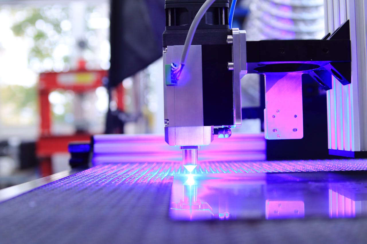 contact-img Close-up of a laser engraving machine working indoors with blue light reflection.